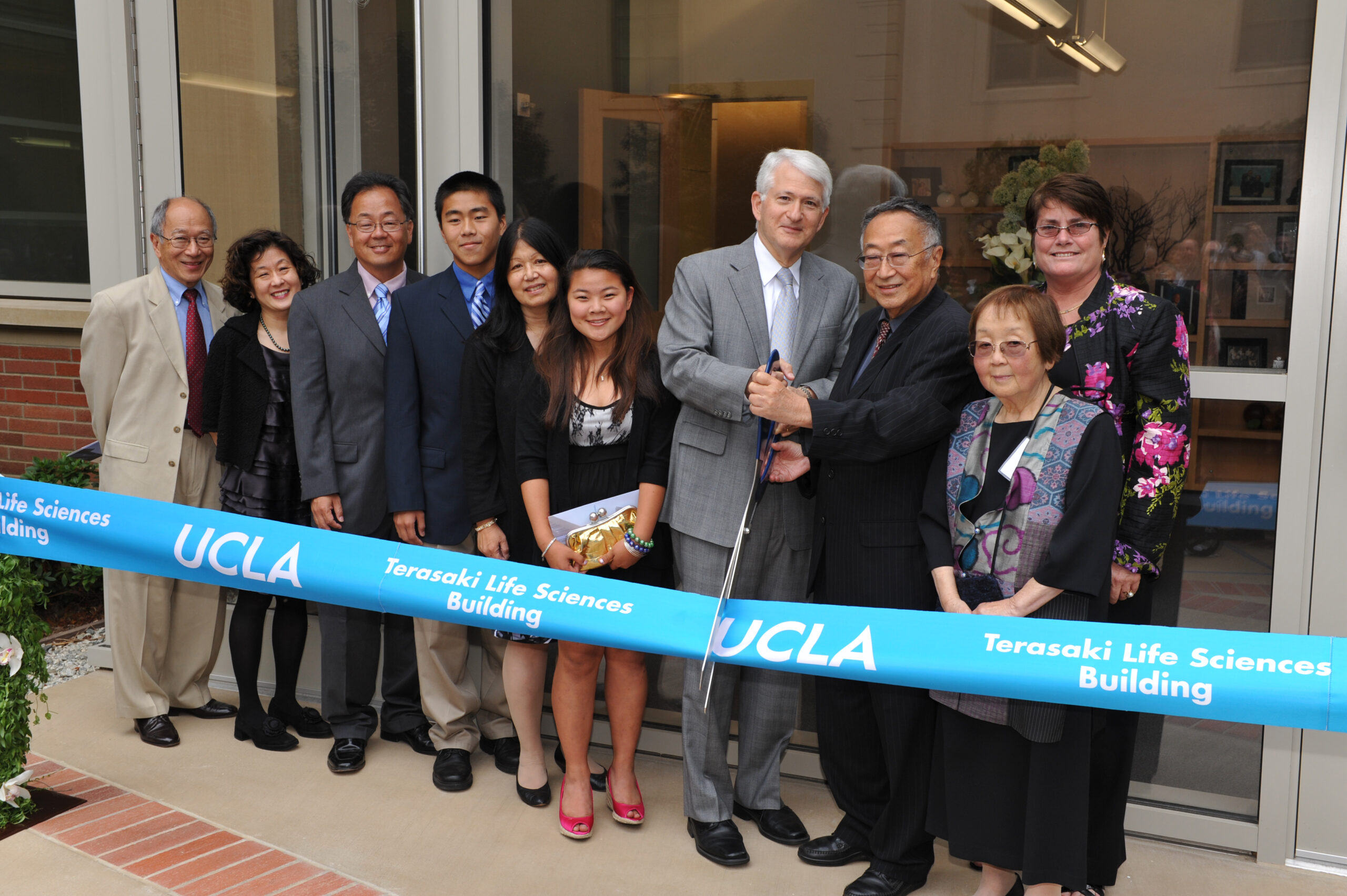 Chancellor Block stands with Paul Tarasaki and others, while cutting ribbon, at the opening of the Terasaki Life Sciences Building