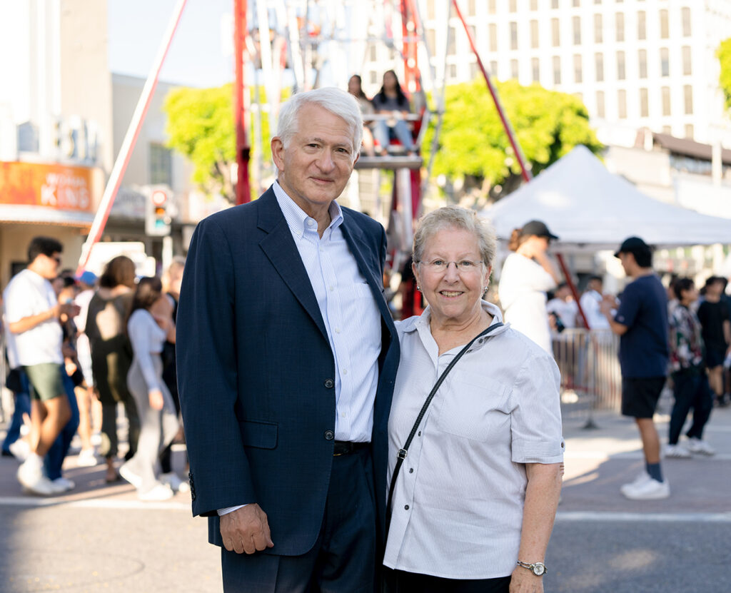 Chancellor Block and his wife Carol pose in front of a ferris wheel during This True Bruin Welcome party introducing students to First Thursdays. 