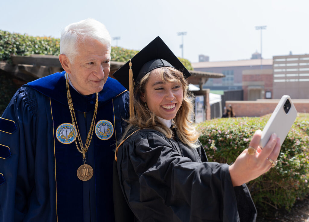Chancellor Block and 2022 commencement keynote speaker Katelyn Ohashi take a selfie outside of Pauley Pavilion.