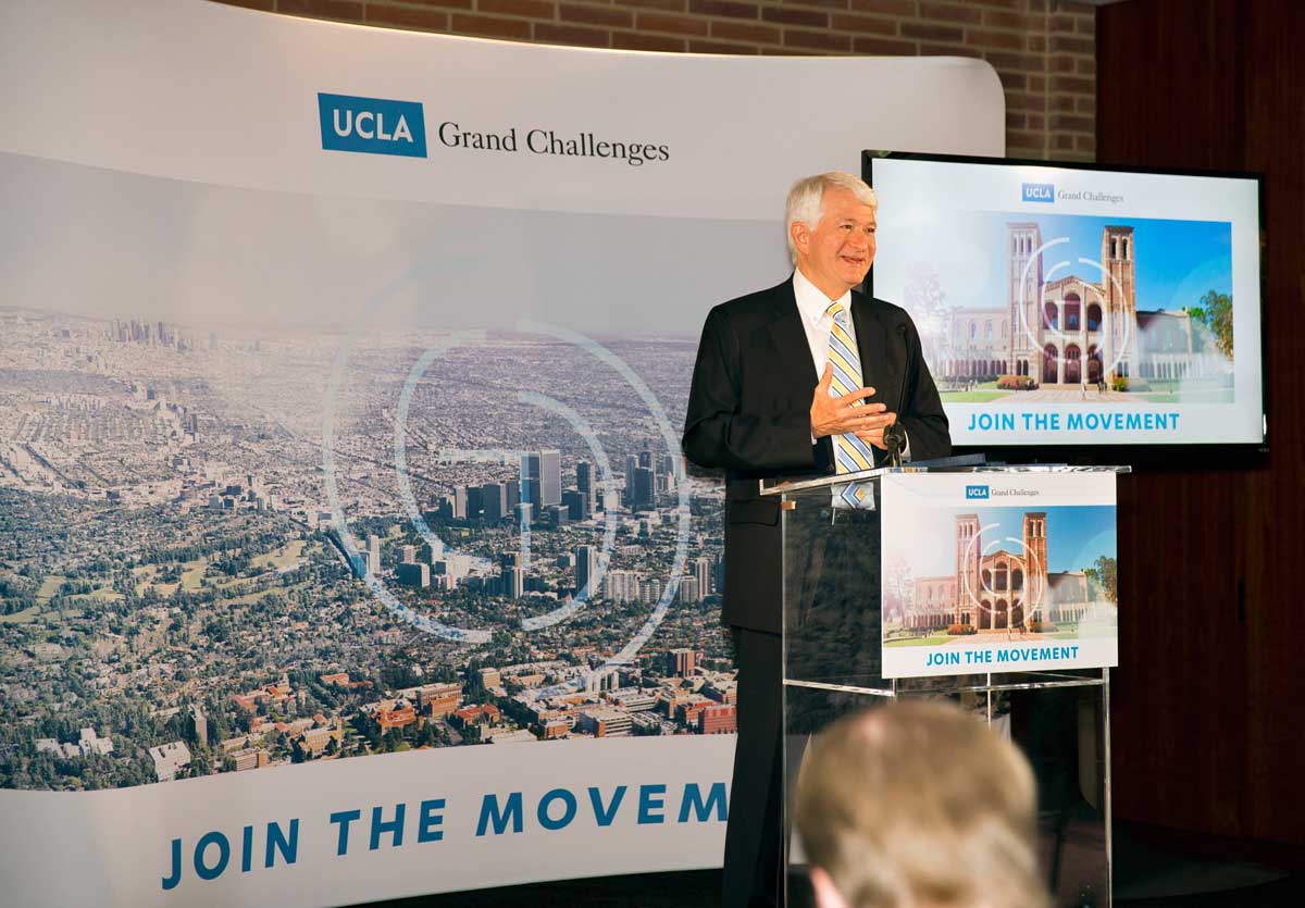 Chancellor Block stands in front of maps of Los Angeles and the UCLA campus, as he introduces the first UCLA Grand Challenge; Sustainability.