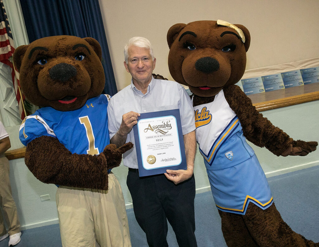 Chancellor Block with Joe and Josie Bruin holds a certificate of recognition from the California State Assembly for UCLA Volunteer Day
