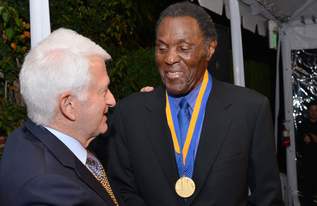 Chancellor Gene Block shakes hands with UCLA Medal recipient and alumnus Rafer Johnson.